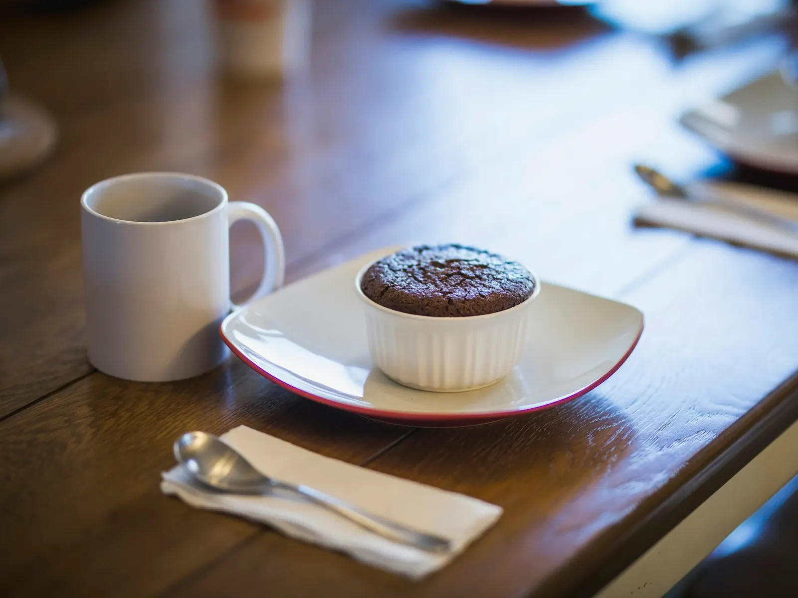 Chocolate protein mug cake next to a coffee cup