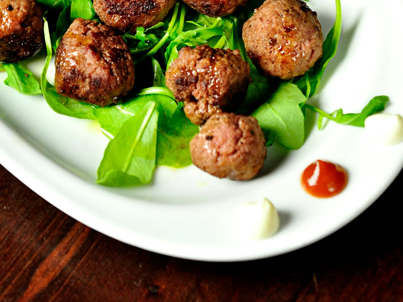 Baked turkey meatballs on a bed of arugula